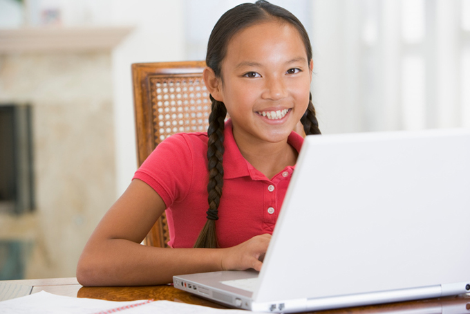 Smiling asian girl at computer