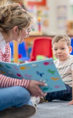 Young teacher reading aloud to preschool students