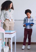 A young teacher with her student at the front of the class presenting